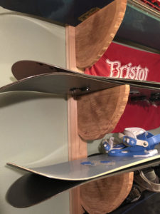 cedar wood round sections mounted on wall for snowboard shelving